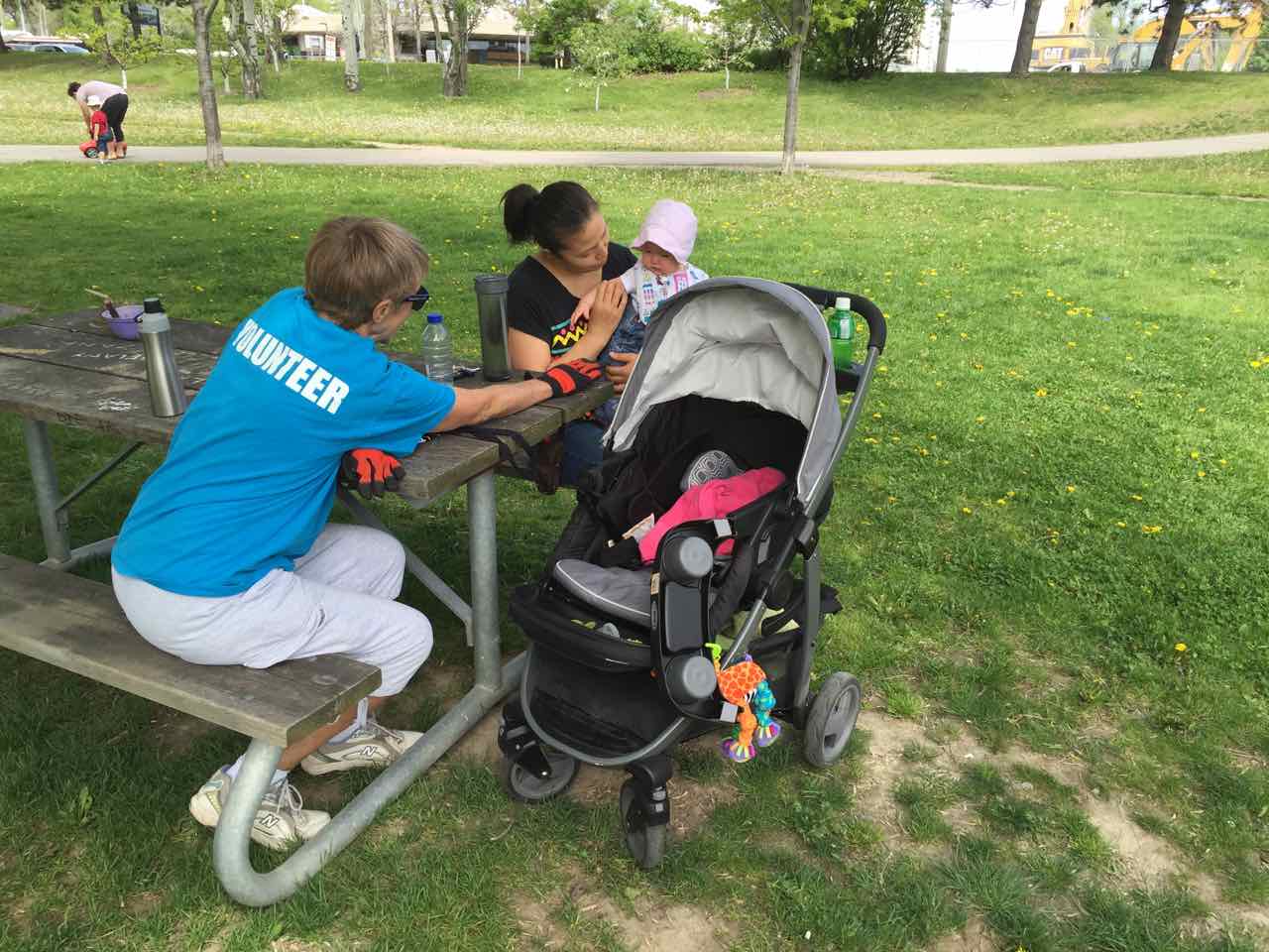 Lynn (in volunteer T-shirt) with Lindsay and her daughter Azalea, at just 6-months , Azalea is Ben Nobleman Park Community Orchard's youngest volunteer!