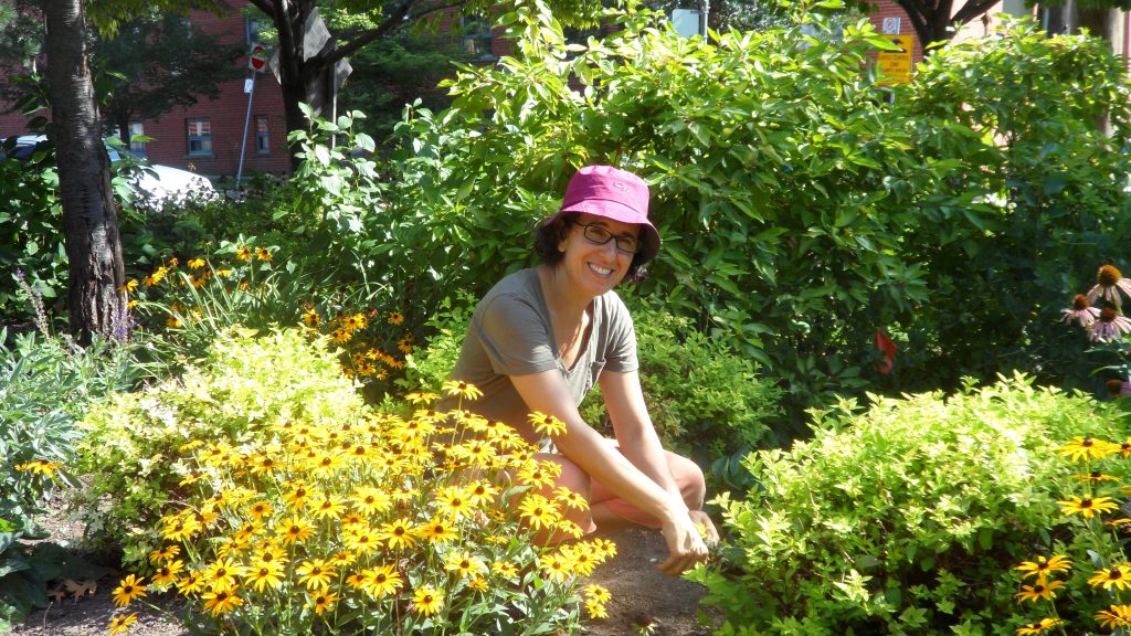 New Ben Nobleman Park Community Orchard volunteer Lily weeds in the pollinator garden. 