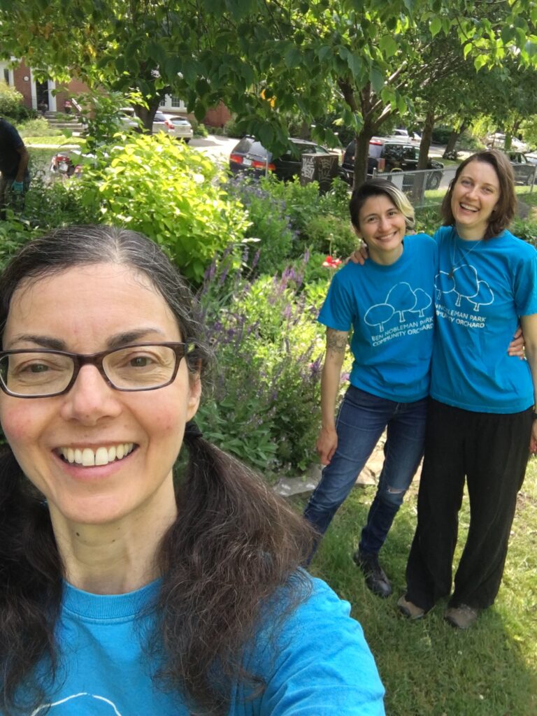 Three women in front of the pollinator garden and farmscaping project.