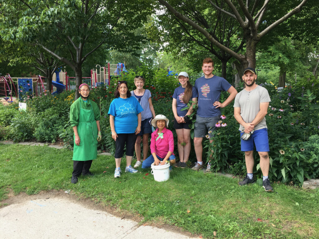 Volunteers pose beside community pollinator garden.