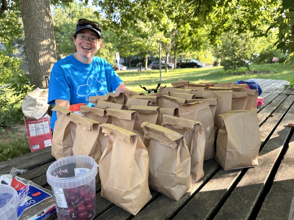 Sara at the harvest table with bags of freshly harvested sweet cherries from the Ben Nobleman Park Community Orchard cherry trees. 