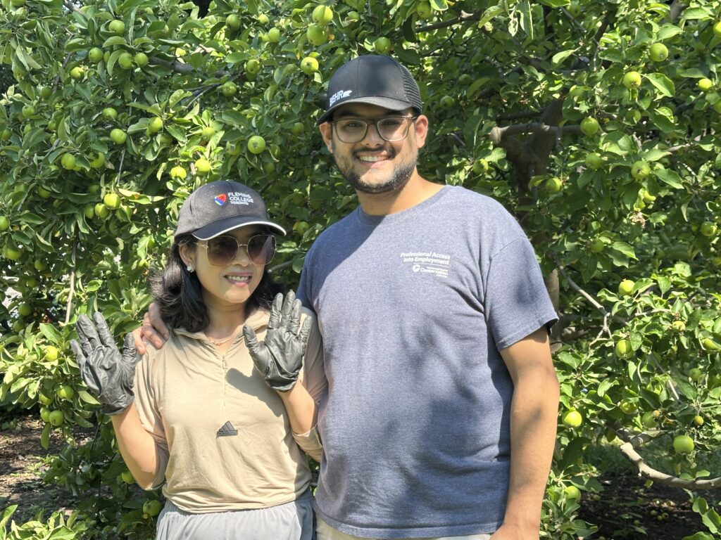 Tila and Kirtan pose in front of one of our apple trees which is heavy with fruit.
