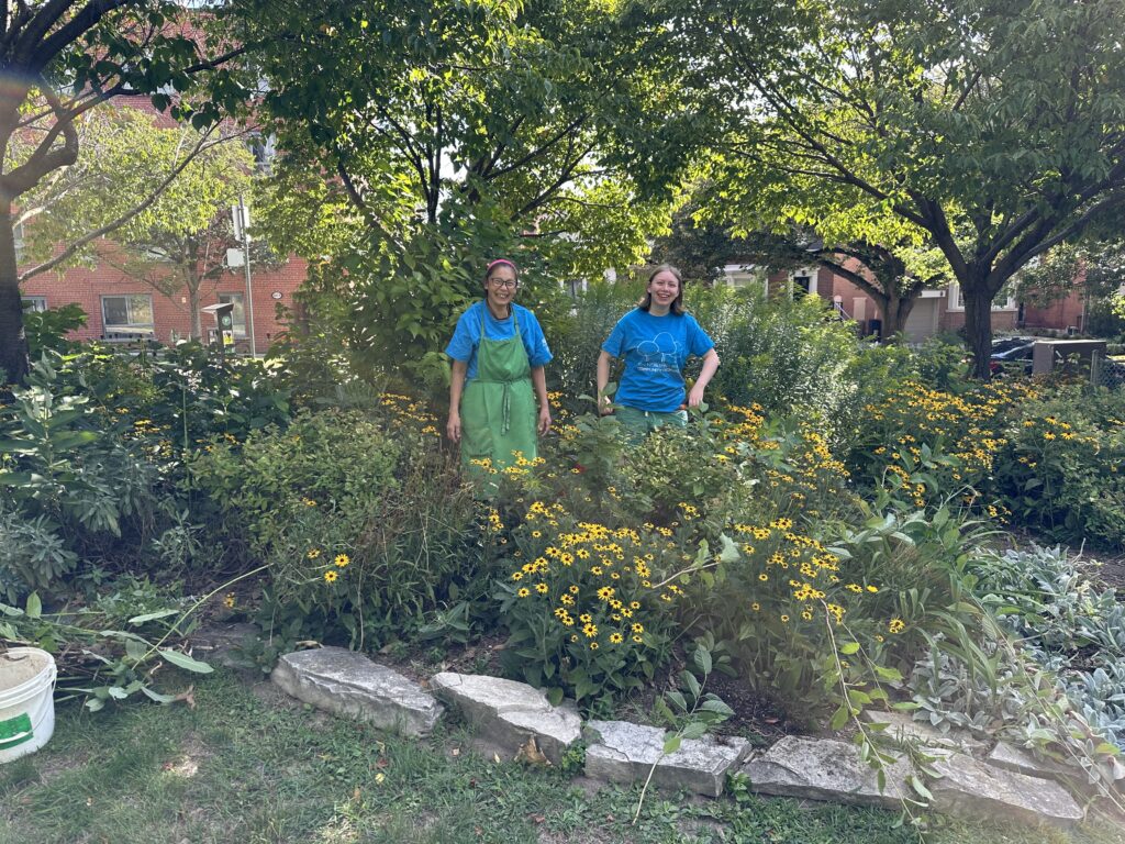 Two women standing in the pollinator garden