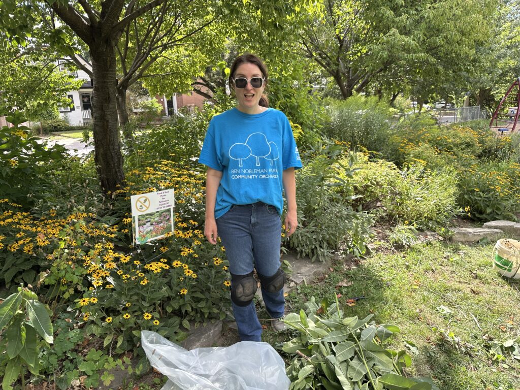 Woman in front of pollinator garden with black eyed susans in background. 