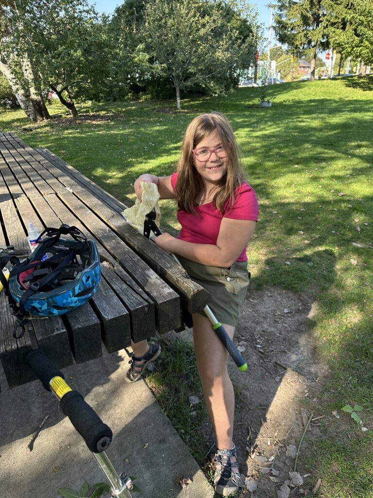 Girl cleaning advil loppers at harvst table. 