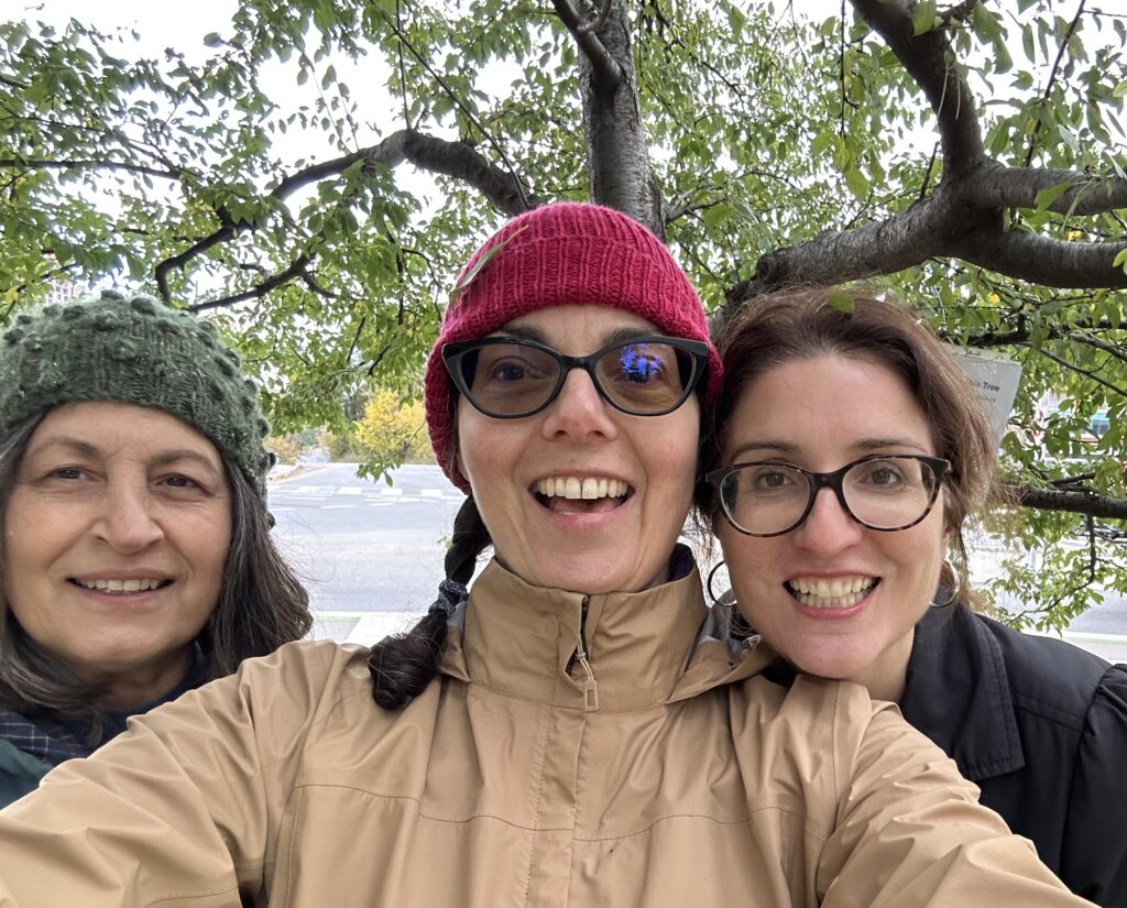 A selfie with Giselle, Susan, and Carolyn smiling after seeing the old plum tree was happy and healthy. 